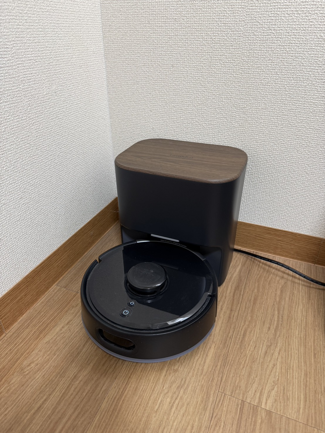 自宅の部屋の隅に設置した黒色のSwitchBot K11+